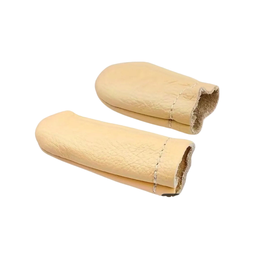 Two beige leather finger protectors on a marble background
