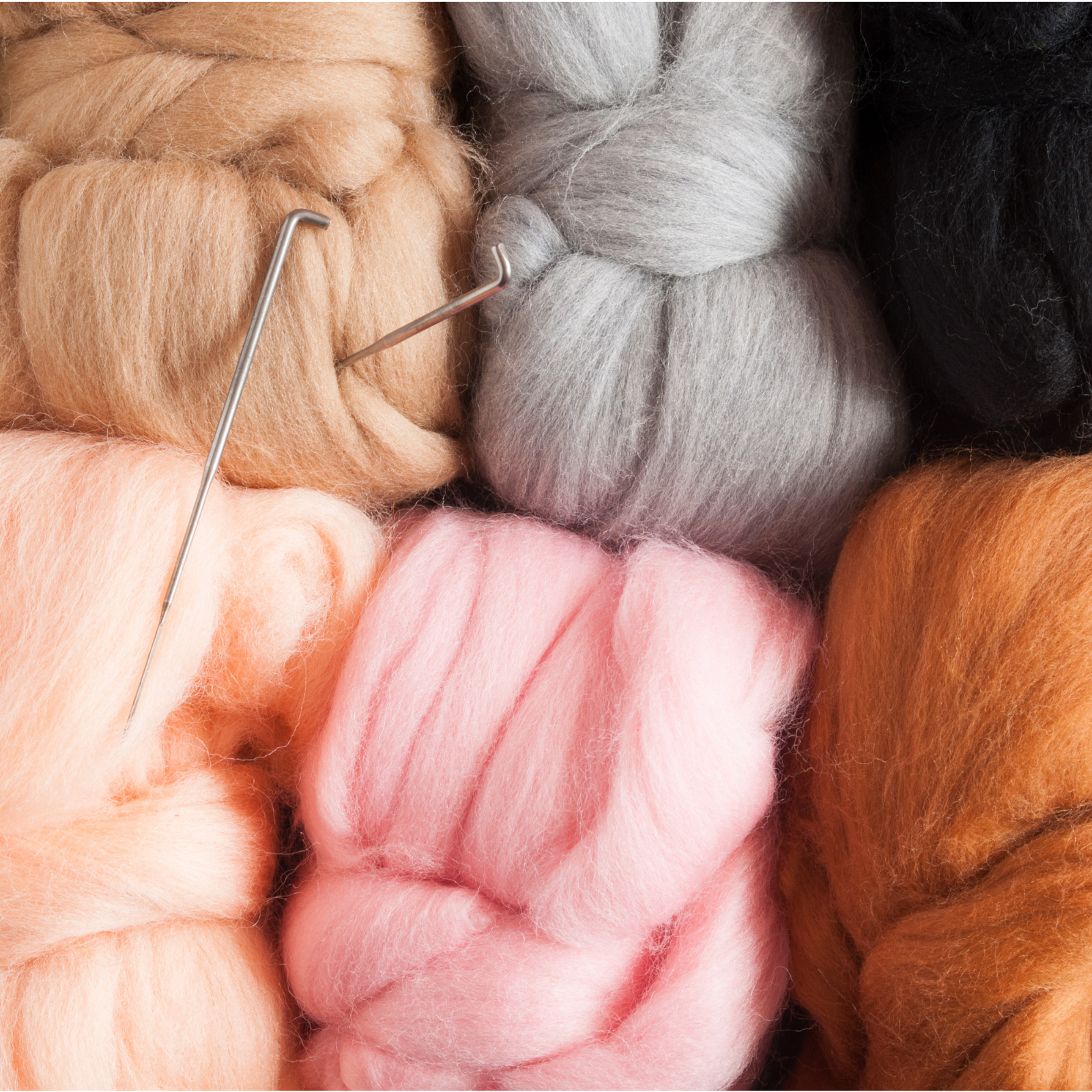 Close-up of colorful yarn bobbins with a needle threaded through them.